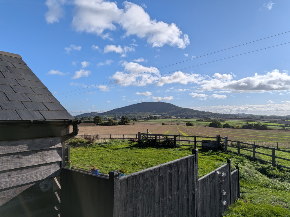 The Wrekin seen across fields from beside the practice, under a blue sky